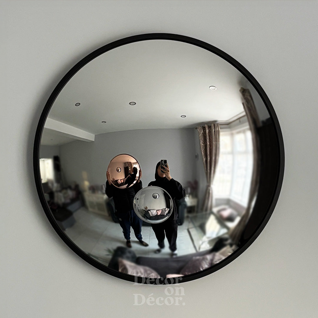 Round convex mirror on a wall with a reflection of a room,
